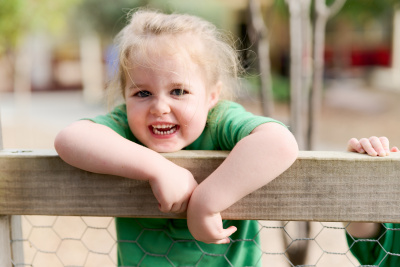 early-learning-student-smiling-on-fence