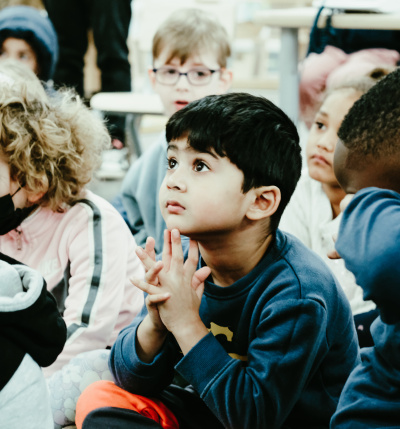 Primary-student-in-class-holding-hand